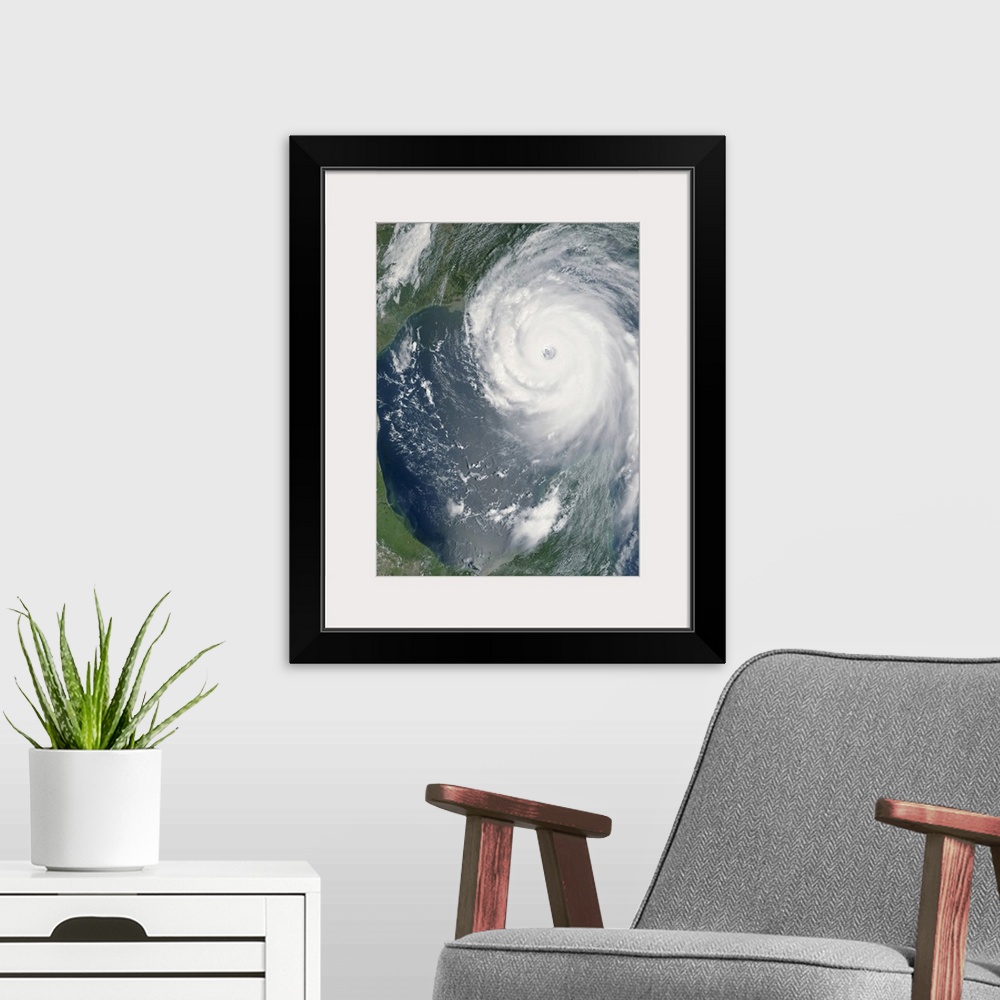 A modern room featuring Big, vertical, aerial photograph of Hurricane Katrina swirling as she approaches land.