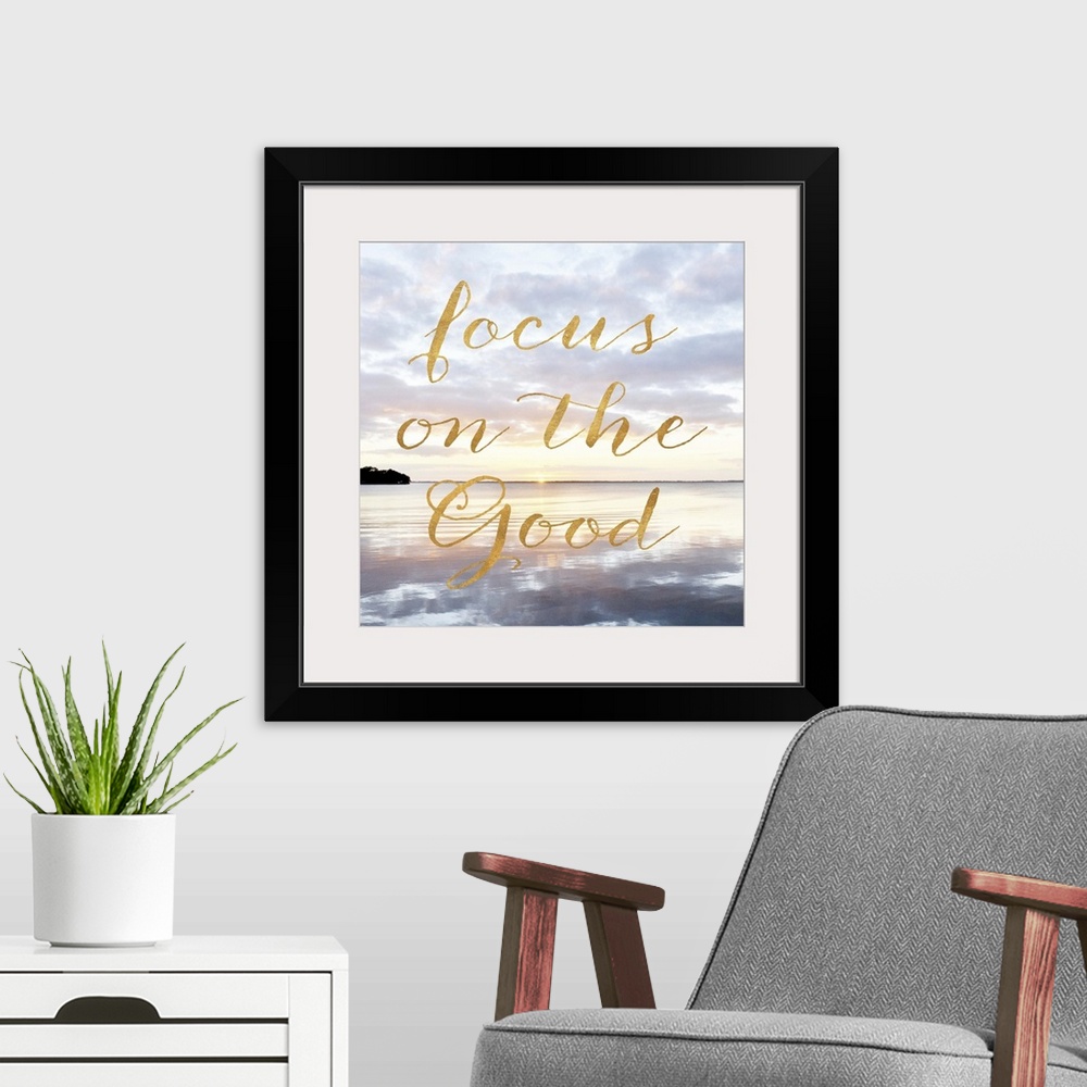 A modern room featuring "Focus on the good" hand written in gold letters over an image of the sea at dawn.