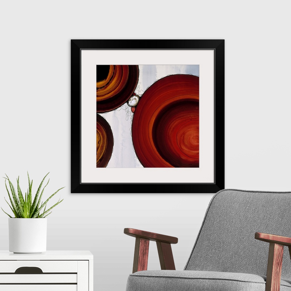 A modern room featuring Abstract painting with a geometric circle designs in red and orange tones on a faded blue and whi...