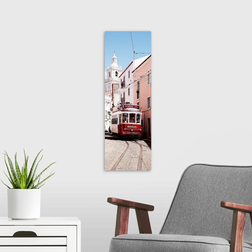 A modern room featuring It's a typical Lisbon street with a church and colorful Facades and the red tram in Portugal.