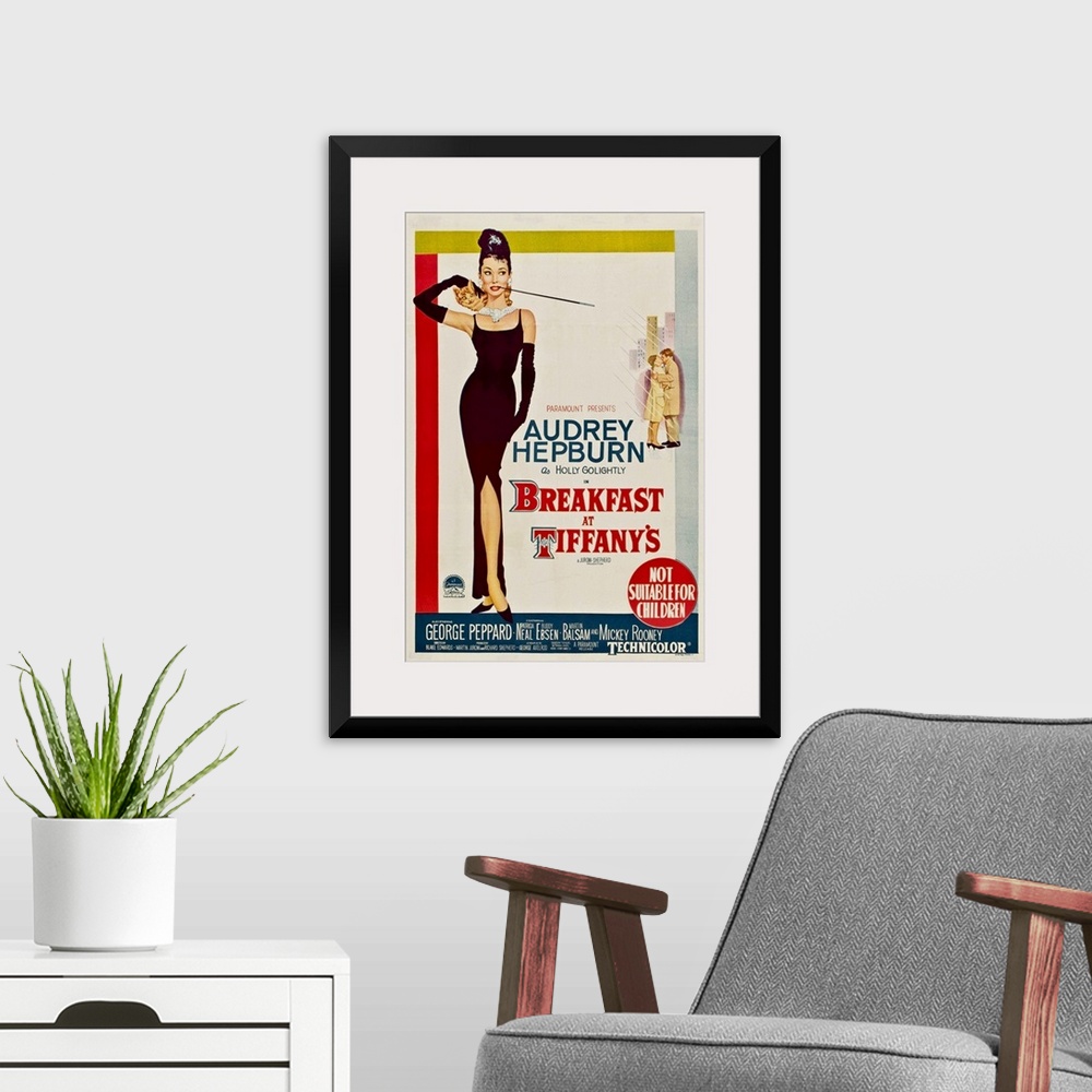 A modern room featuring Vertical, large vintage advertisement for the movie "Breakfast At Tiffany's", with actress Audrey...