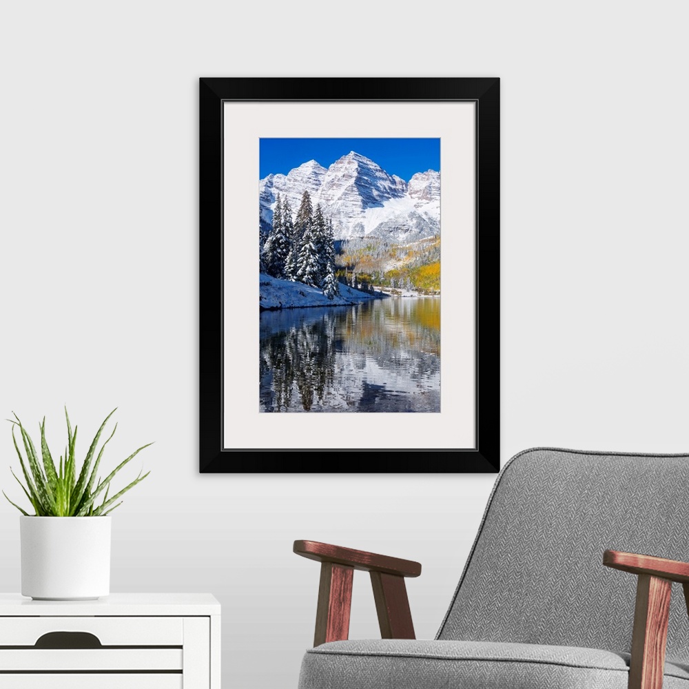 A modern room featuring Snow covered mountains are pictured against a clear blue background that reflects down in the bod...