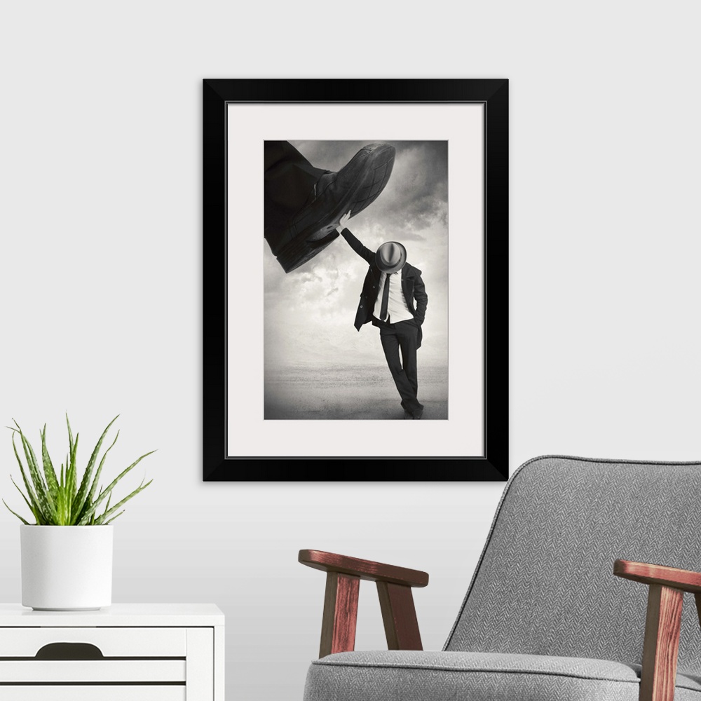 A modern room featuring An abstract art photograph of a man wearing a hat and suit, leaning against a giant foot trying t...