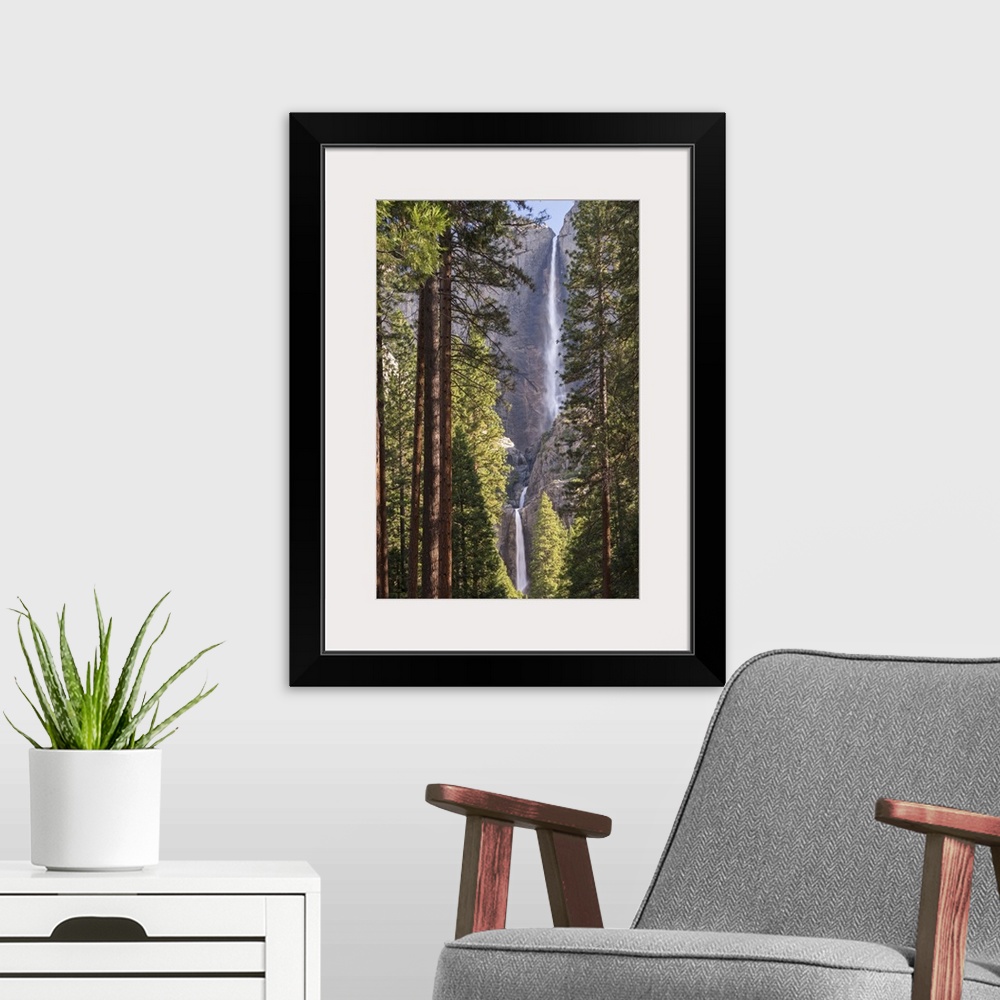 A modern room featuring Yosemite Falls through the conifer woodlands of Yosemite Valley, California, USA. Spring (June) 2...