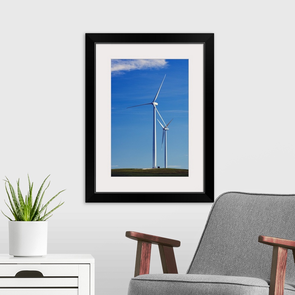 A modern room featuring Pair of wind farm turbines in green grass, blue sky, Montana