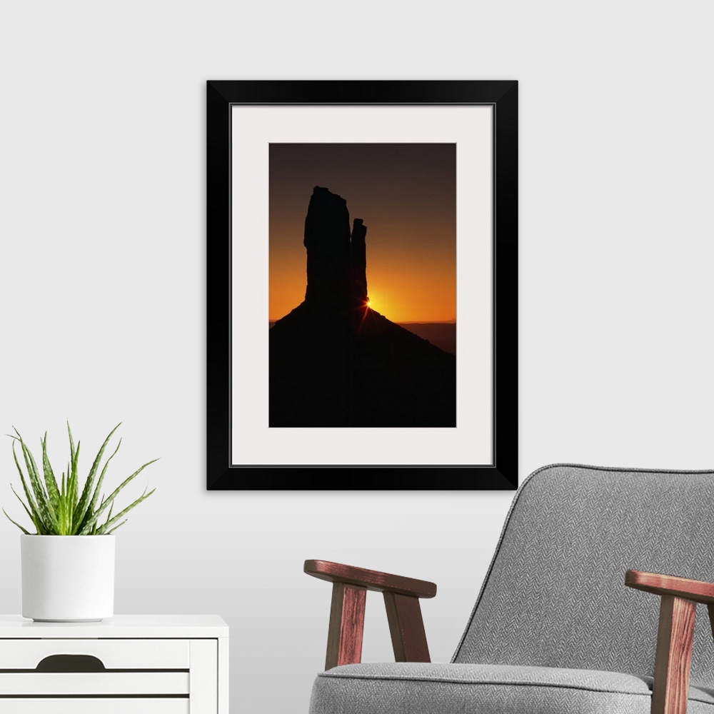 A modern room featuring Sunrise behind silhouetted sandstone formation, Monument Valley, Utah