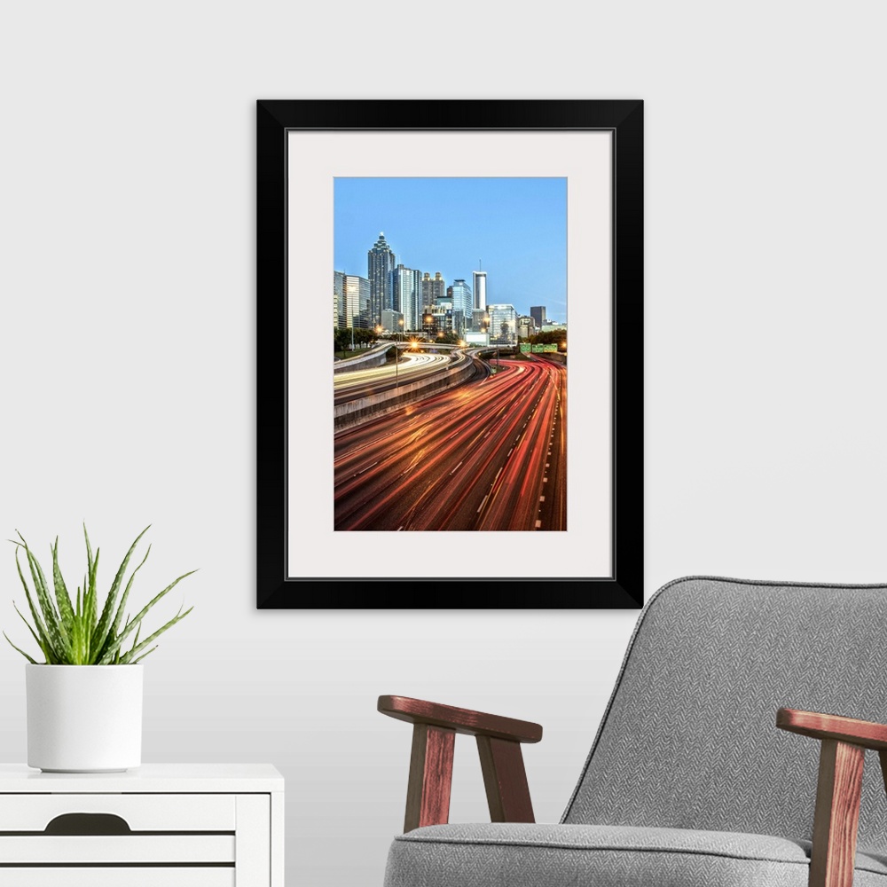A modern room featuring Light trails on the street from passing vehicles leading towards the city skyline of Atlanta, Geo...