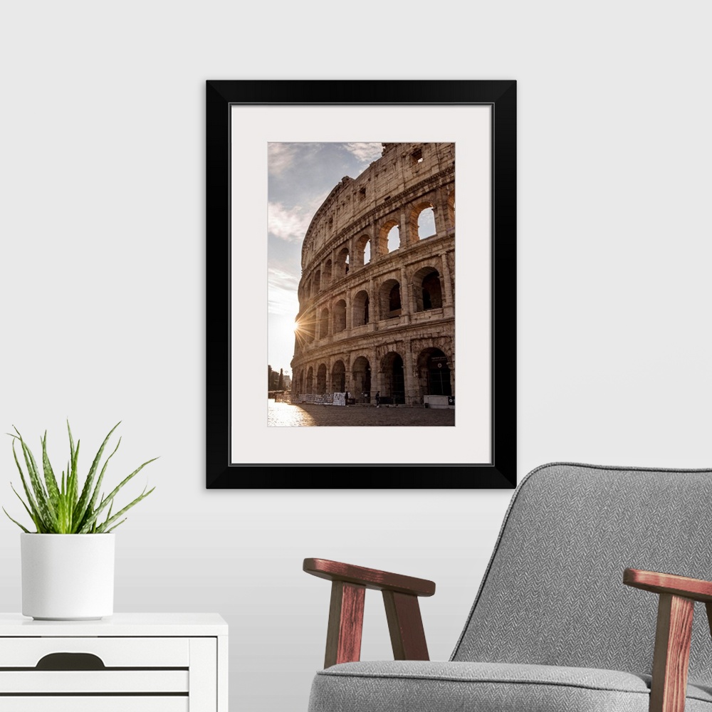 A modern room featuring Photograph of the sun shining on the side of the Colosseum in Rome on a beautiful day.
