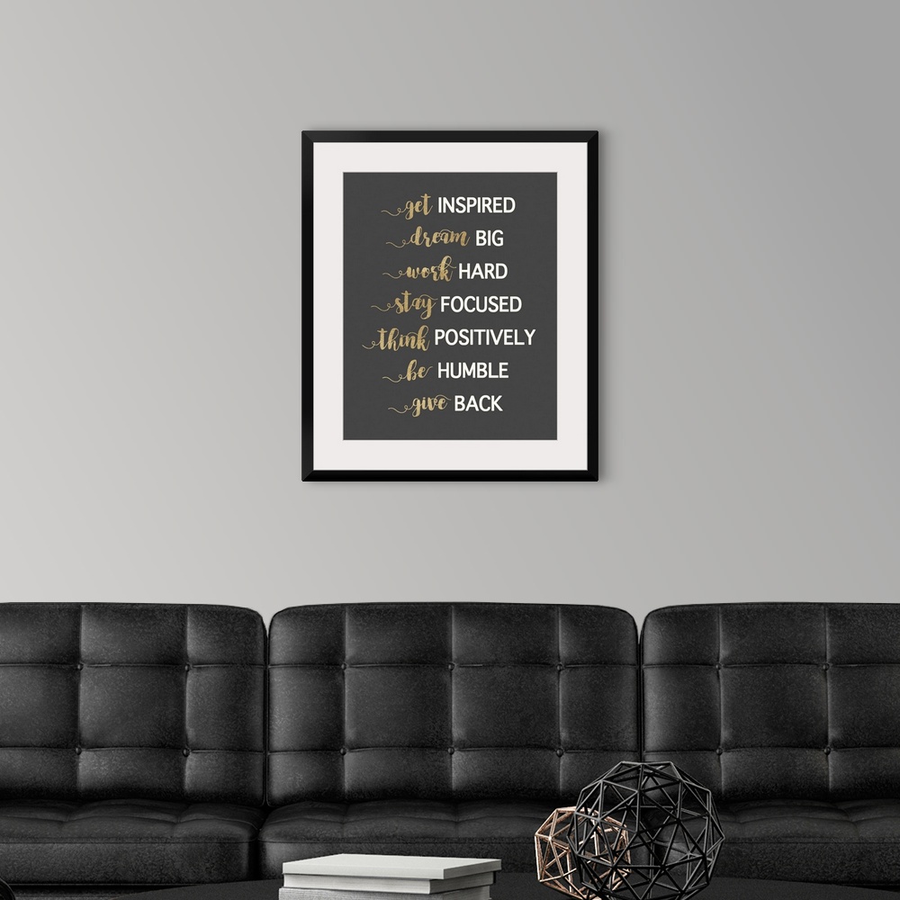 A modern room featuring Typography artwork in gold and white on dark grey of motivational phrases.