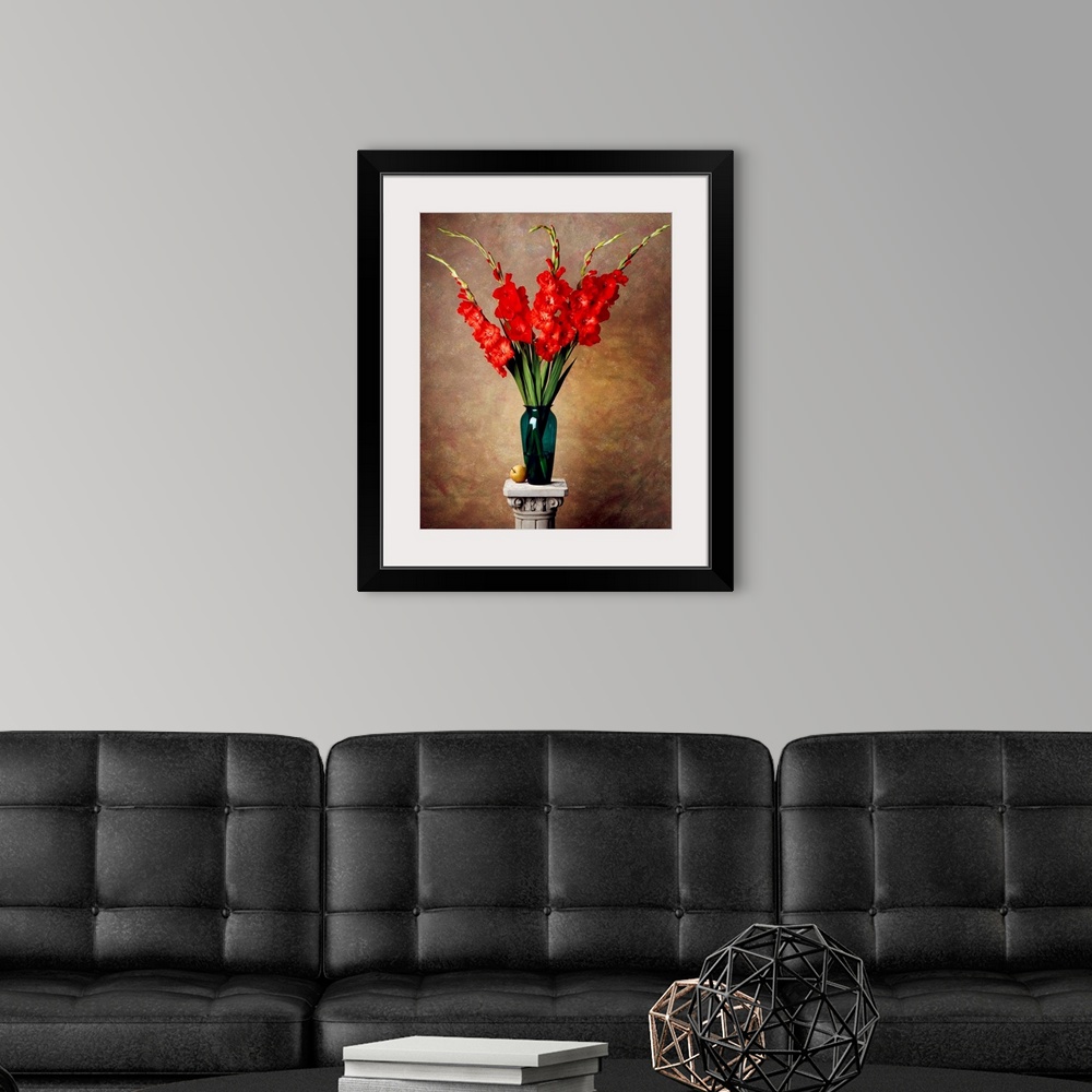 A modern room featuring Red gladiolas in a vase on a pedestal