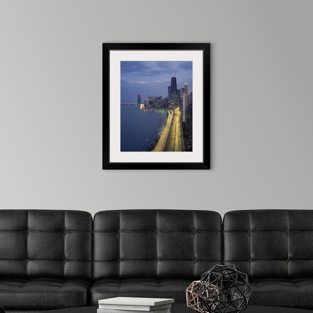 A modern room featuring Vertical panoramic photograph at dusk with city skyline in the distance and busy highway and stre...
