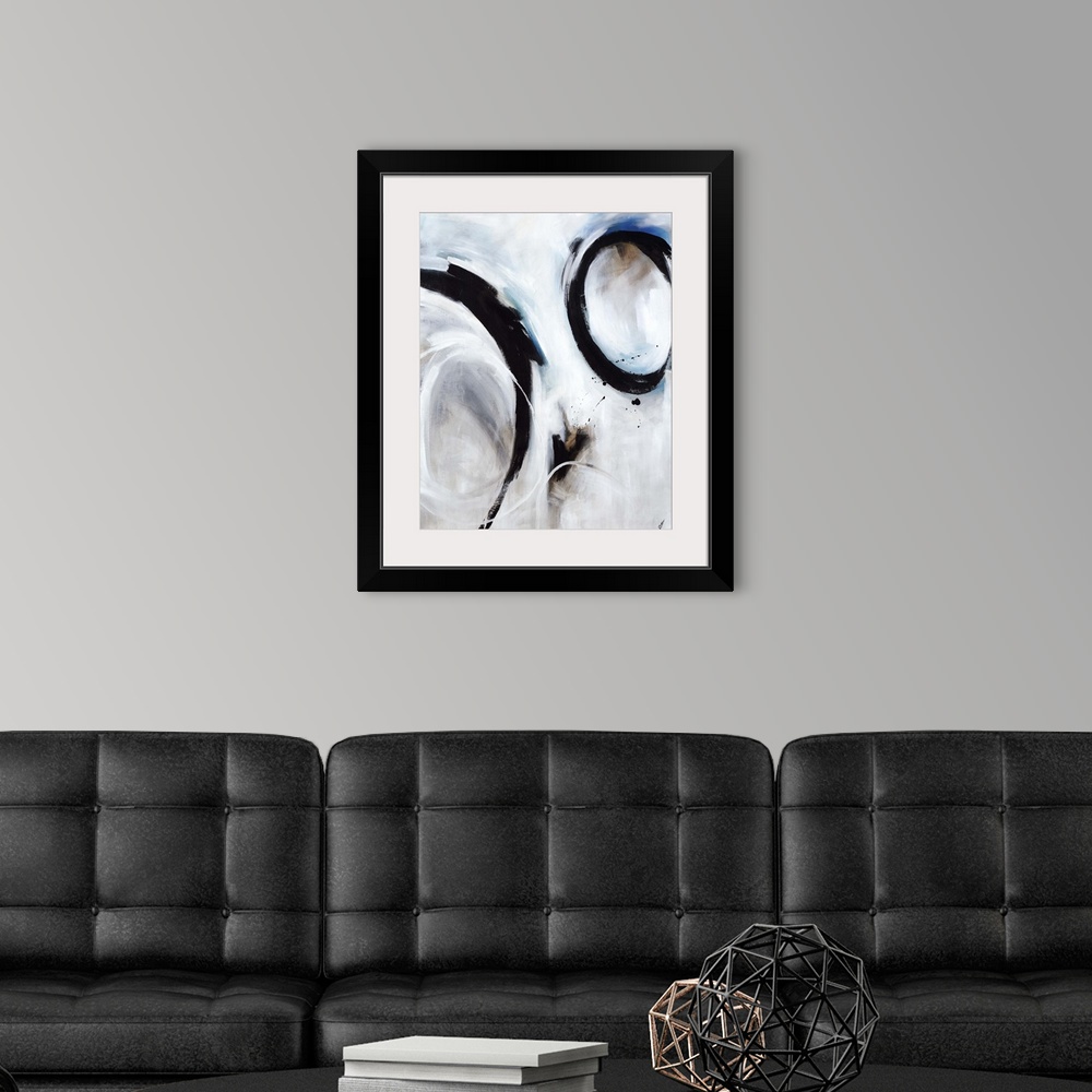 A modern room featuring Abstract artwork of strong black circular strokes over a soft blue and grey background.