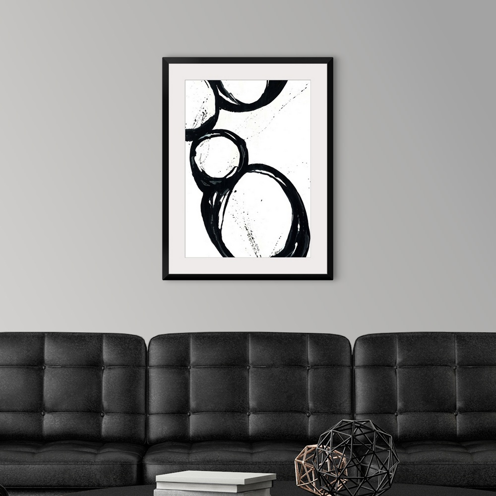A modern room featuring Large vertical abstract modern artwork of different sized circular designs on a blank background.