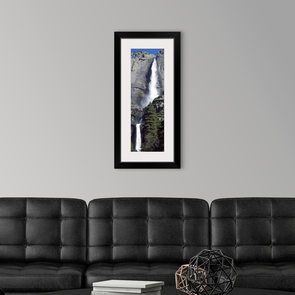 A modern room featuring A narrow and vertical shaped photograph of the majestic Yosemite Falls in late spring with heavy ...