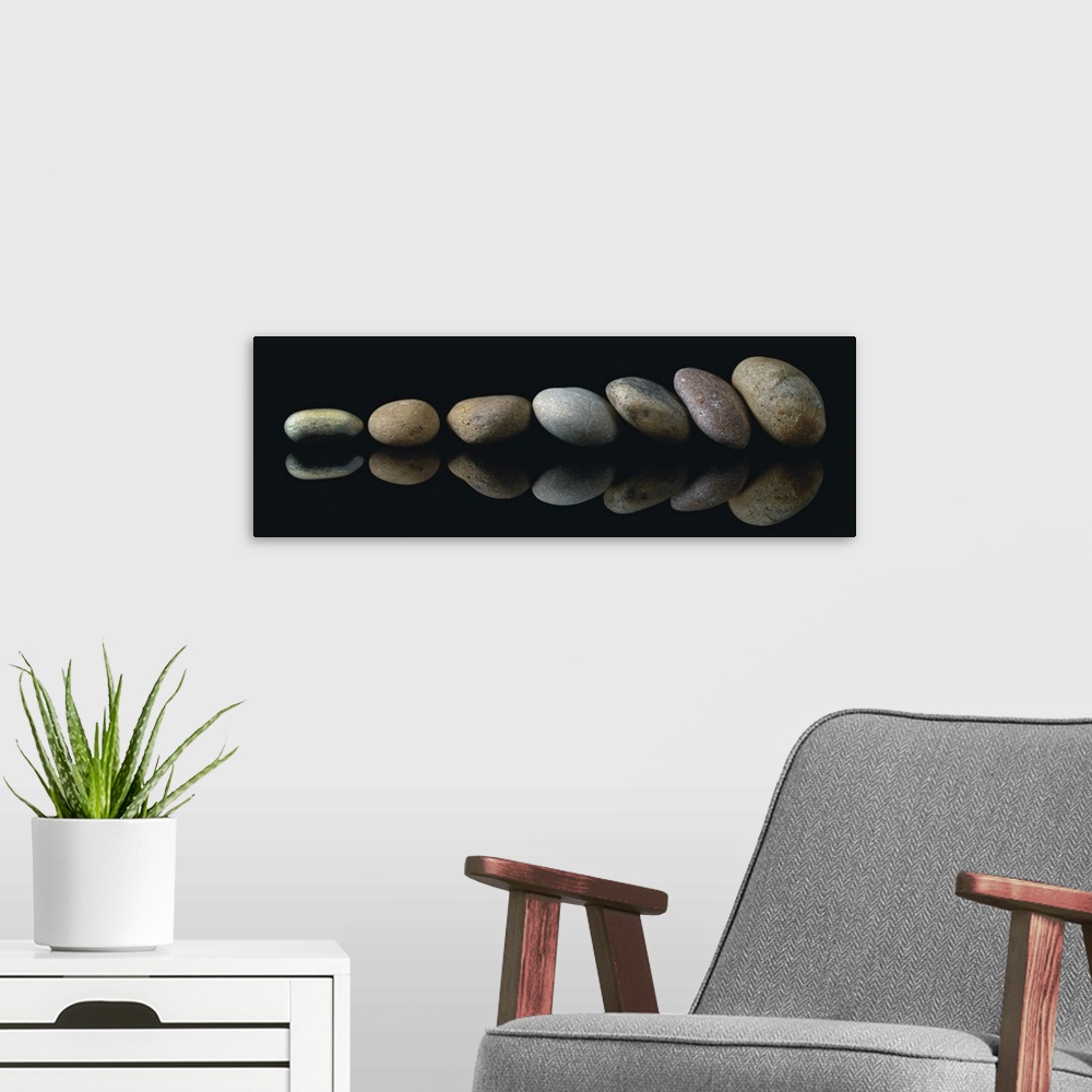 A modern room featuring A panoramic photograph of a row of smooth rocks leaning against each other.