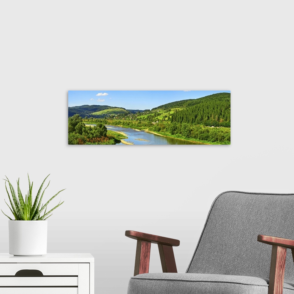 A modern room featuring Carpathian mountain summer landscape with river, sky, and clouds.