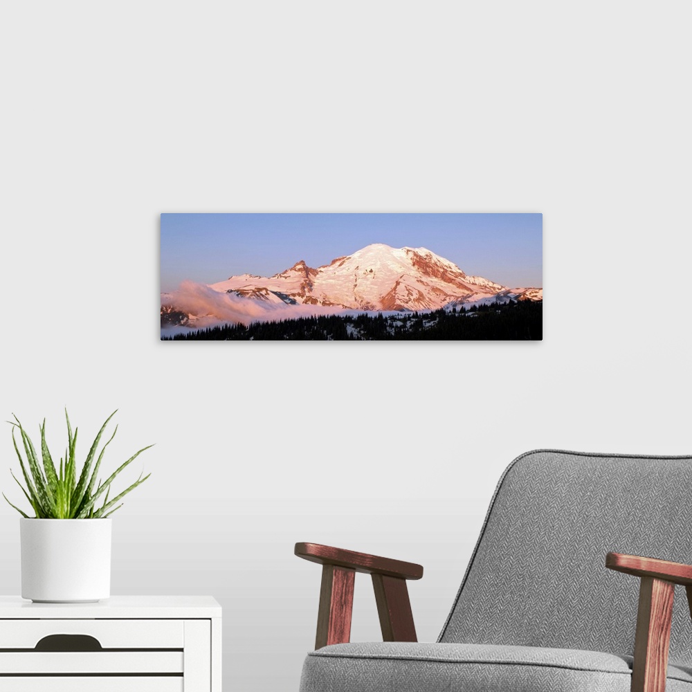 A modern room featuring Morning light making Mount Rainier appear slightly pink.