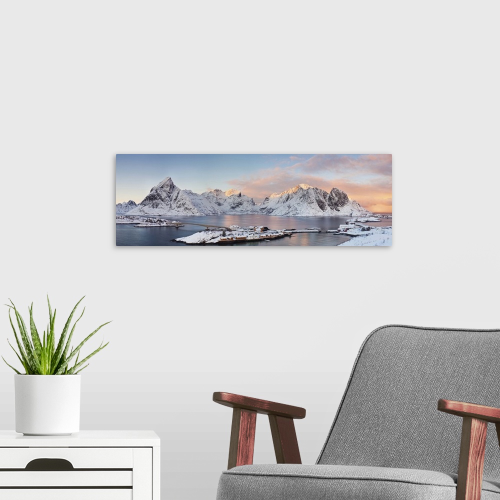 A modern room featuring Panaromic view of Reina and Hamnoy at the end of Lofoten Islands during winter sunset. Two villag...