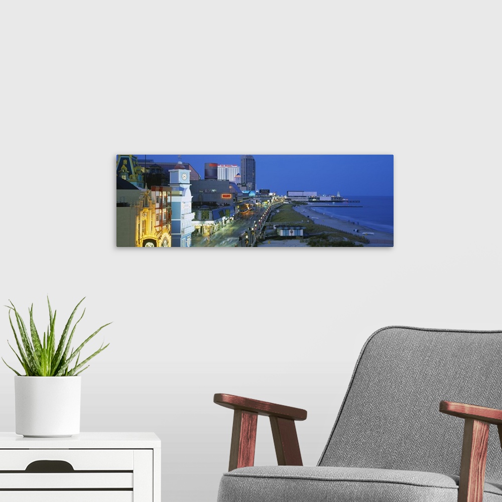 A modern room featuring Panoramic photograph of skyline along boardwalk and oceanfront at dusk.