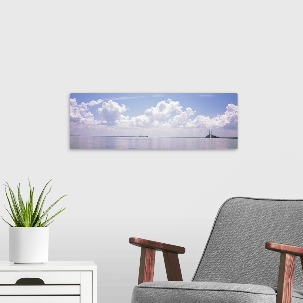 A modern room featuring Sea with a container ship and a suspension bridge in distant, Sunshine Skyway Bridge, Tampa Bay, ...