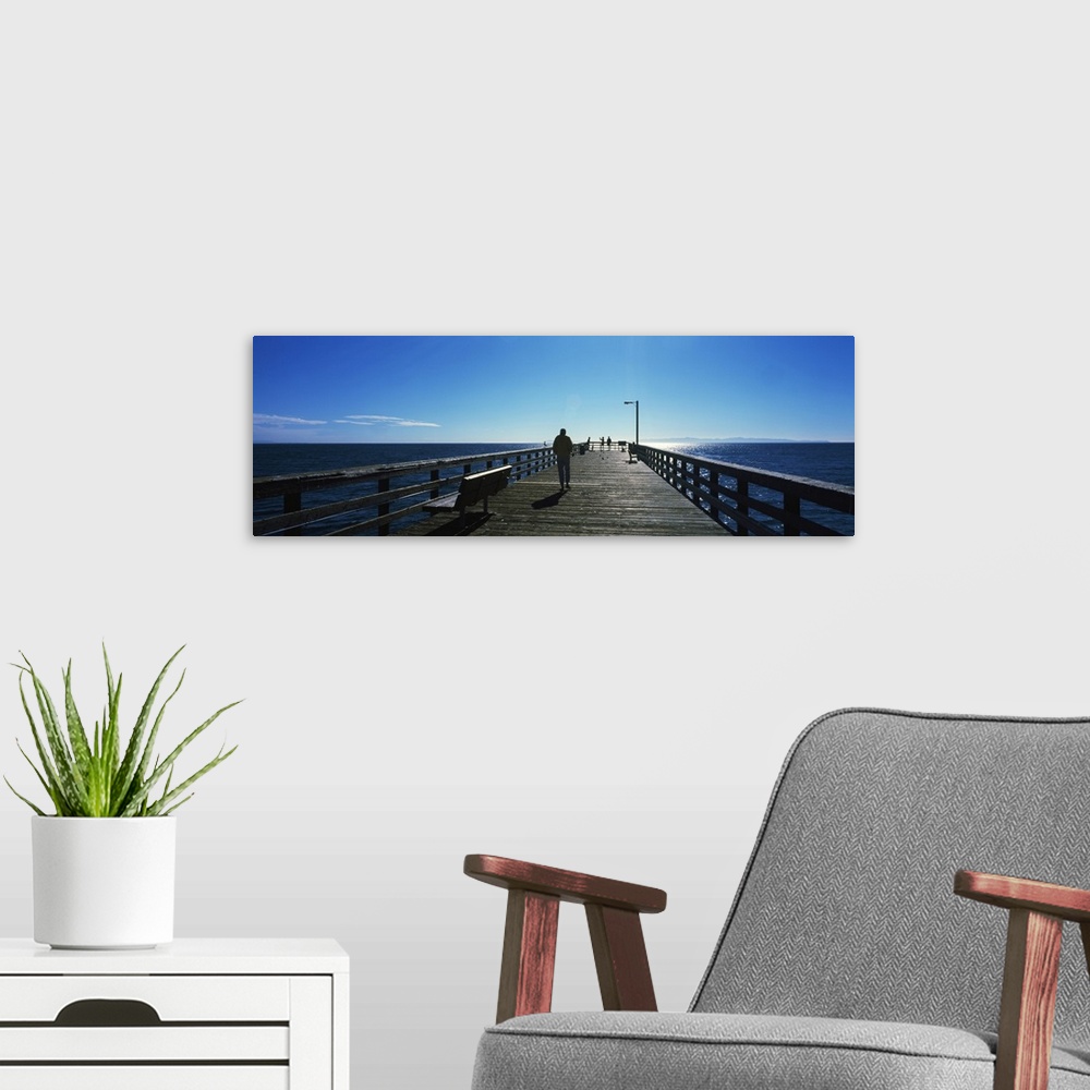 A modern room featuring Silhouette of a person walking on a pier, Goleta Beach Pier, Goleta, California, USA
