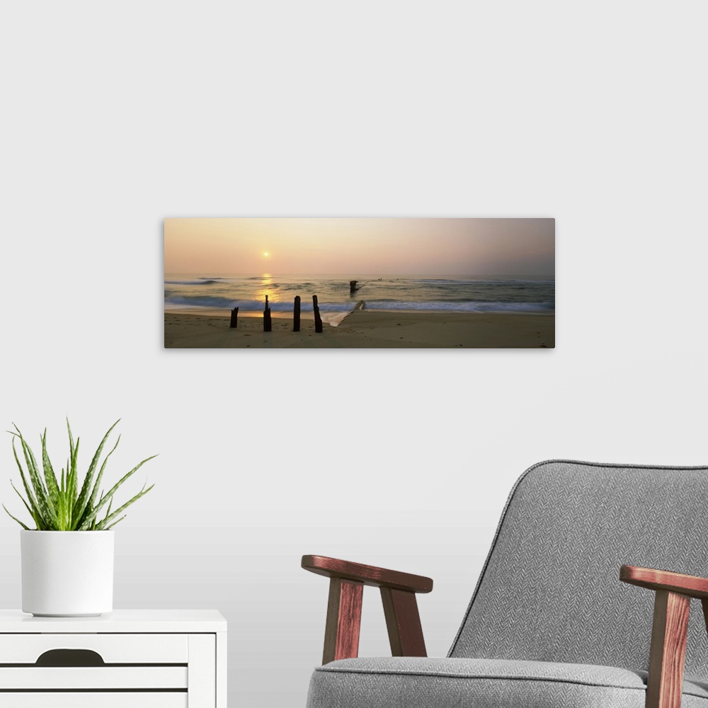 A modern room featuring Posts and tide break on the beach at sunrise, Cape Hatteras National Seashore, North Carolina, USA