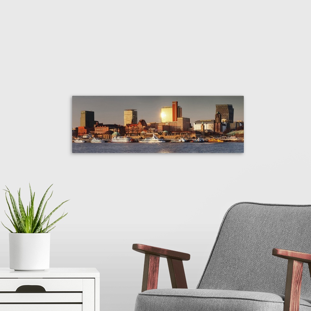 A modern room featuring View from Elbe River to St. Pauli Landungsbruecken pier and skyscraper Tanzende Tuerme at sunset,...