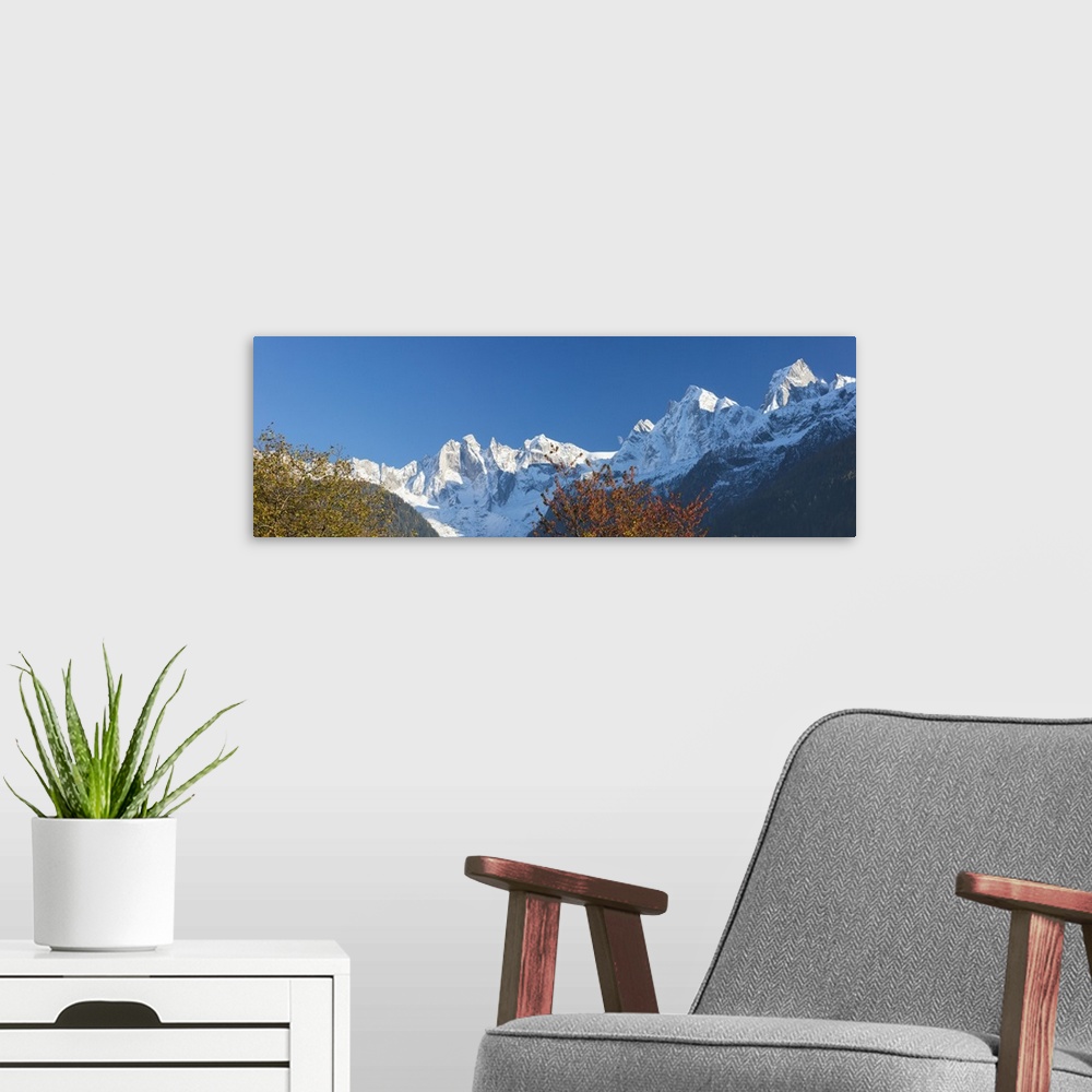A modern room featuring Panorama of the snowy peaks framed by colorful trees, Soglio, Bregaglia Valley, Canton of Graubun...