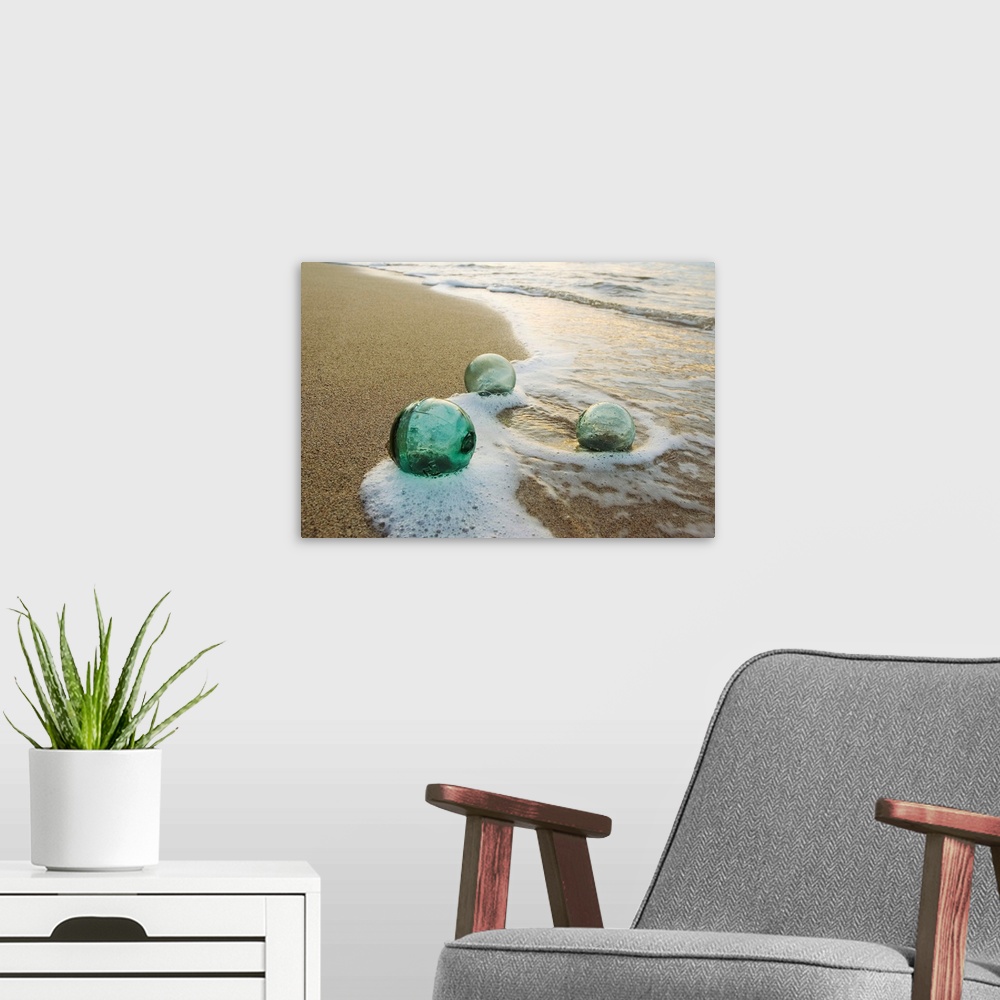 Three Glass Fishing Floats Roll On The Sandy Shoreline with Ripples of Water and Seafoam | Large Solid-Faced Canvas, Black Floating Frame Wall Art