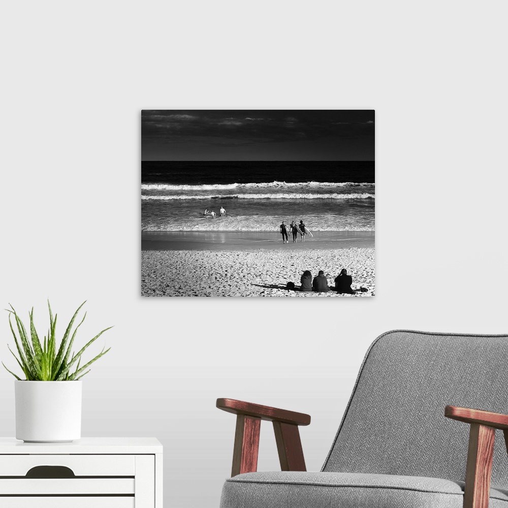 A modern room featuring Square black and white photograph of people in groups of 3 enjoying the beach in different ways, ...