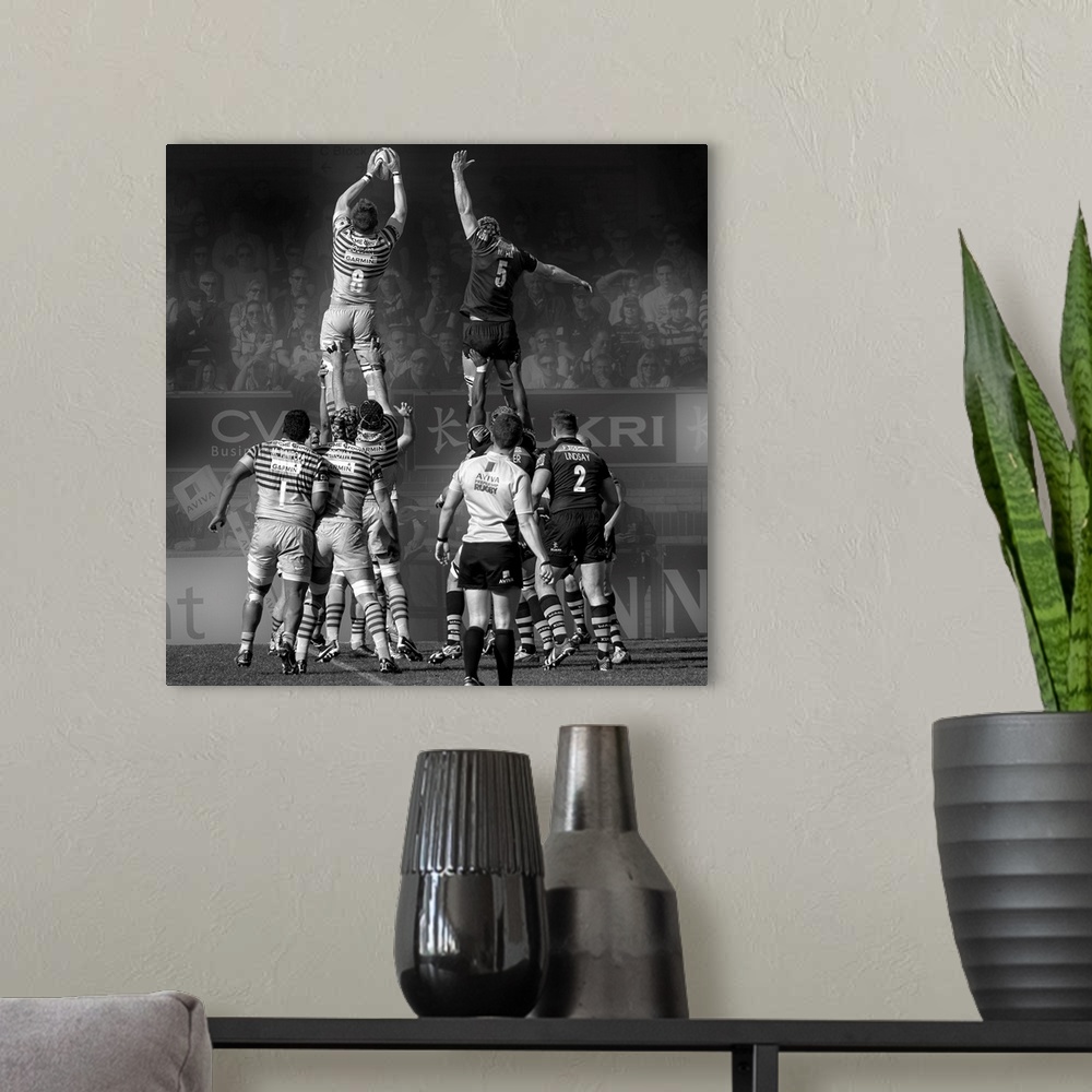 A modern room featuring A black and white photograph of rugby players in a match reaching into air to grasp the ball.