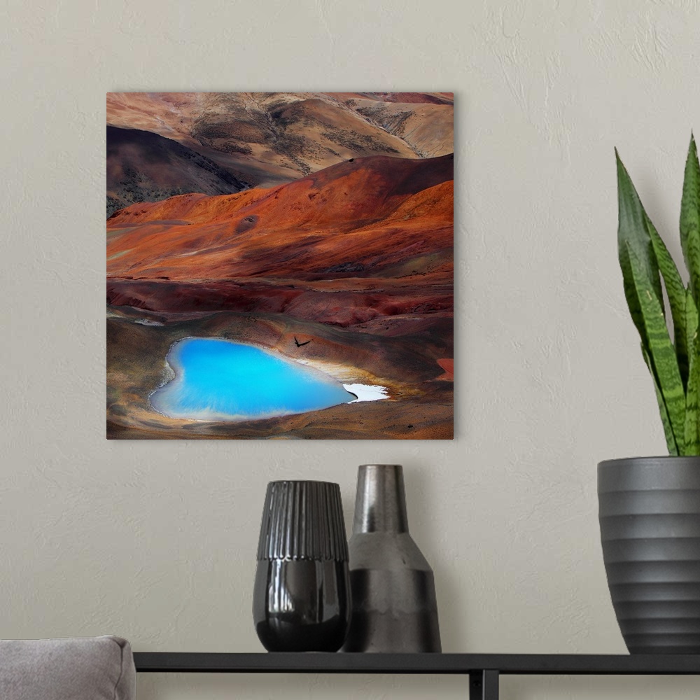 A modern room featuring A bright blue heart-shaped lake contrasts with the orange hills of the surrounding desert.