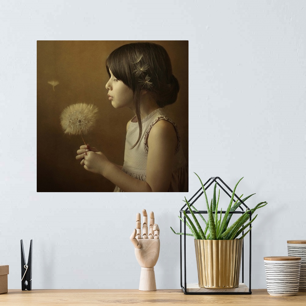 A bohemian room featuring A little girl holding a giant dandelion full of seeds, about to blow the wisps away.