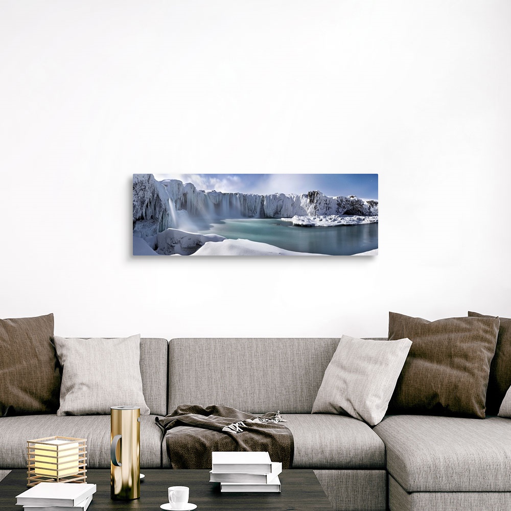 A traditional room featuring Icy snow covered landscape with waterfalls streaming down from cliffs surrounding a river.
