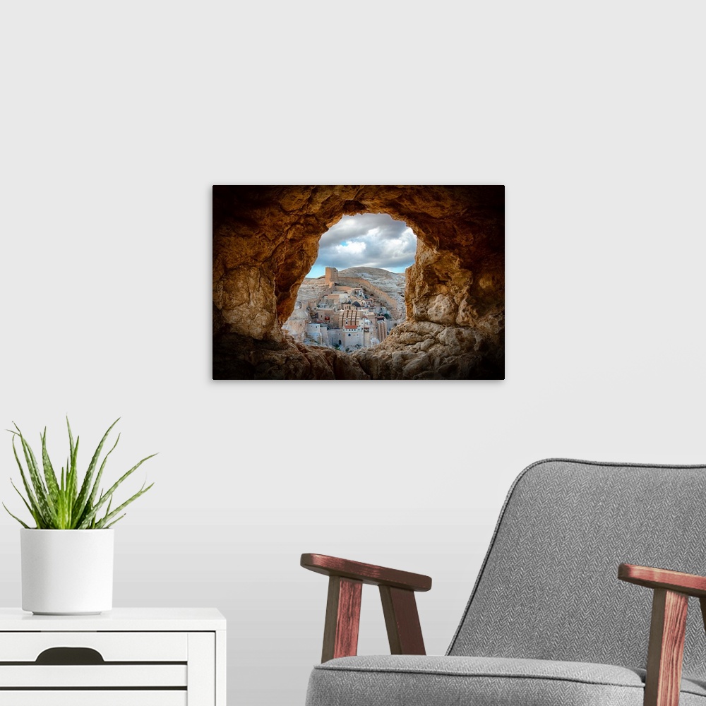 A modern room featuring View of Mar Saba Monastery in Israel from a hole in a rocky wall.
