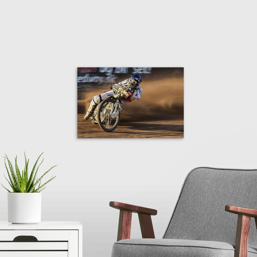 A modern room featuring A motocross racer learning into a curve at the Fjelsted Speedway, Denmark.