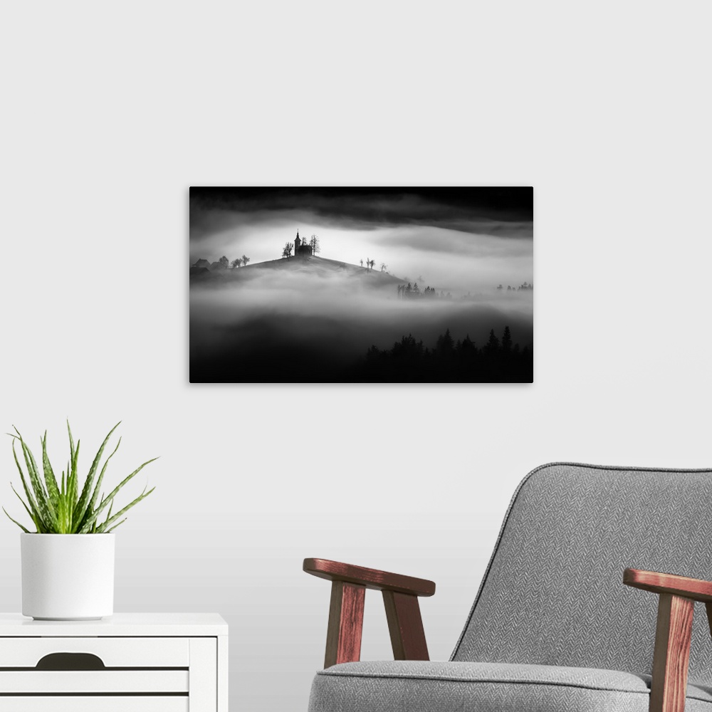 A modern room featuring A church perched on a hill in the fog in Slovenia.