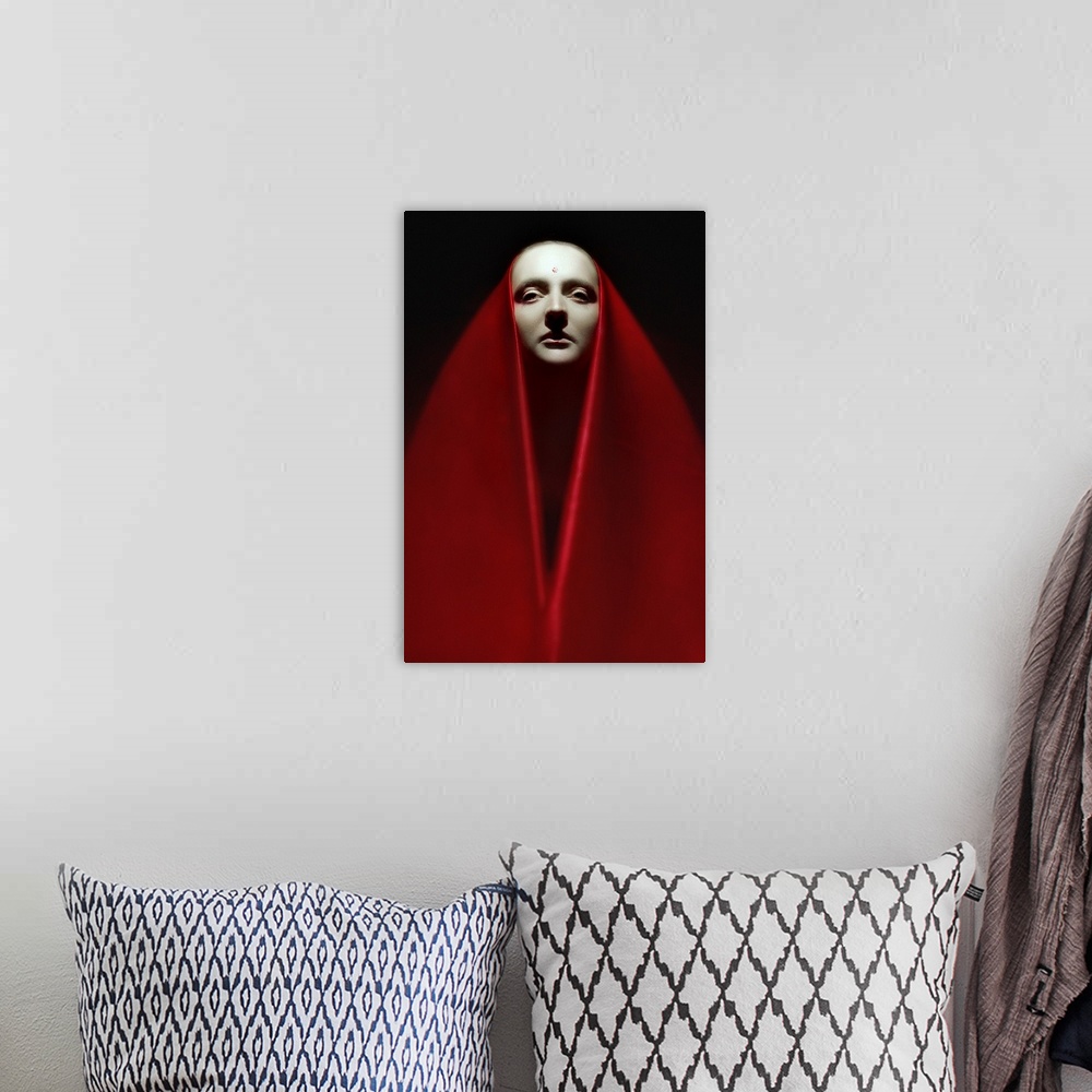 A bohemian room featuring Portrait of a person wearing a long red veil over their head and around their body.