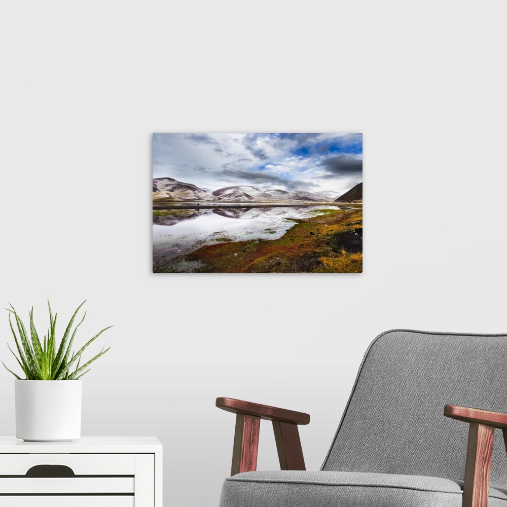 A modern room featuring A cloudy sky over the mountain landscape of Eastern Tibet.