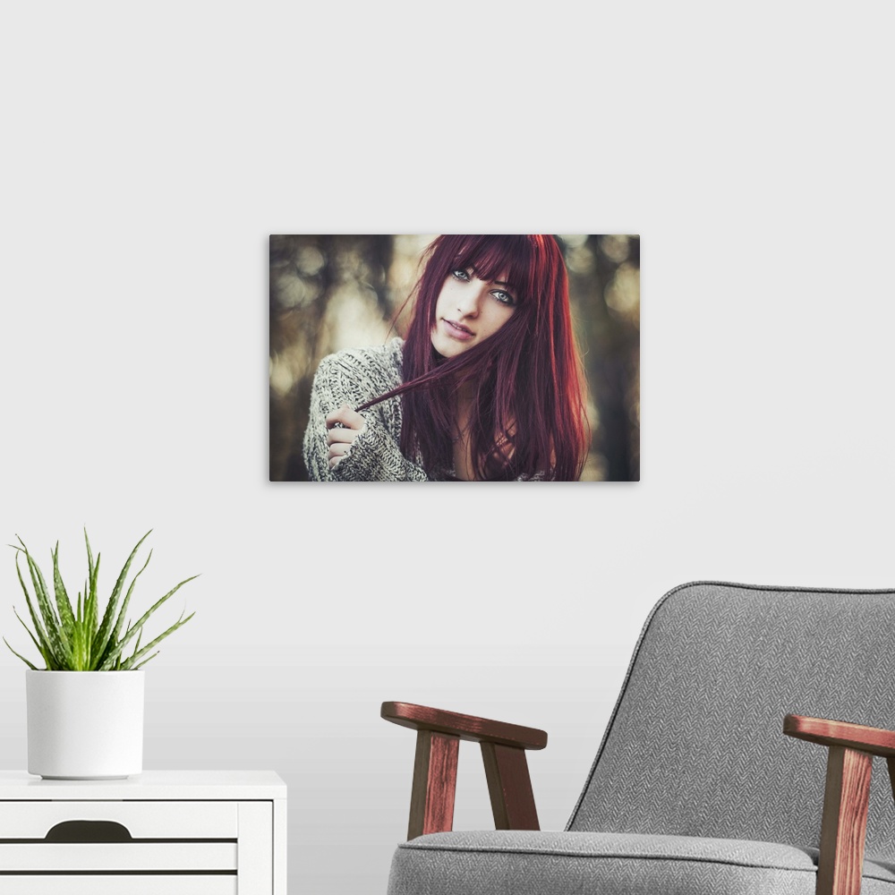 A modern room featuring Portrait of a beautiful young woman with dark red hair.