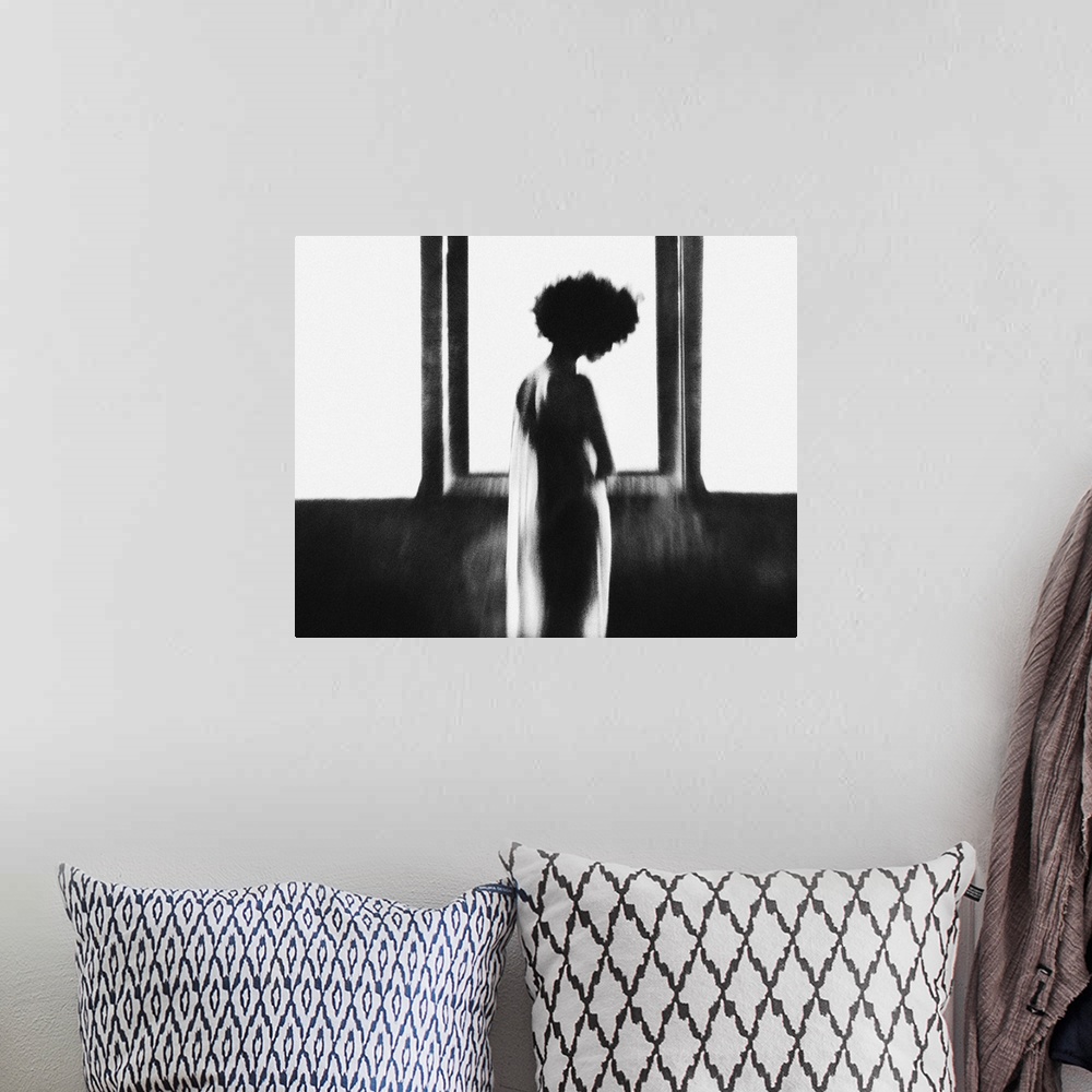 A bohemian room featuring A silhouetted female figure in sheer cloth stands in front of a large glowing window.