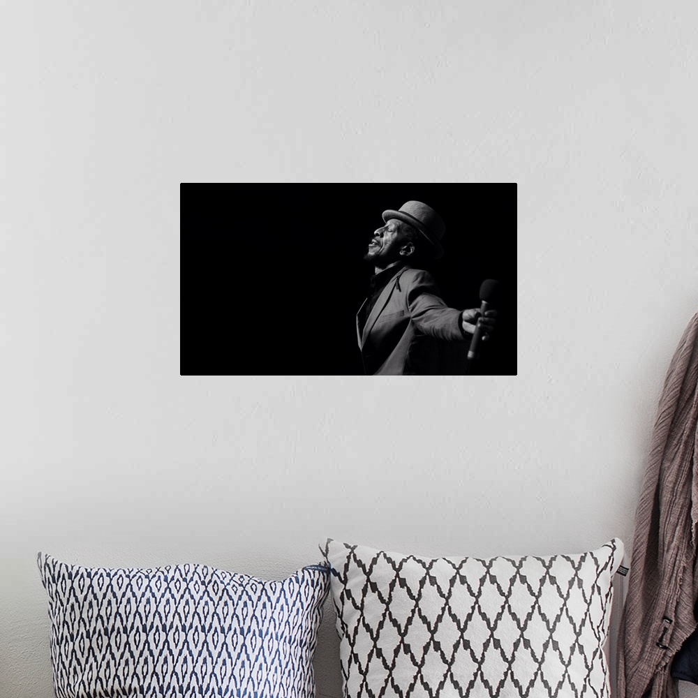 A bohemian room featuring A black and white portrait of a musician giving a performance.