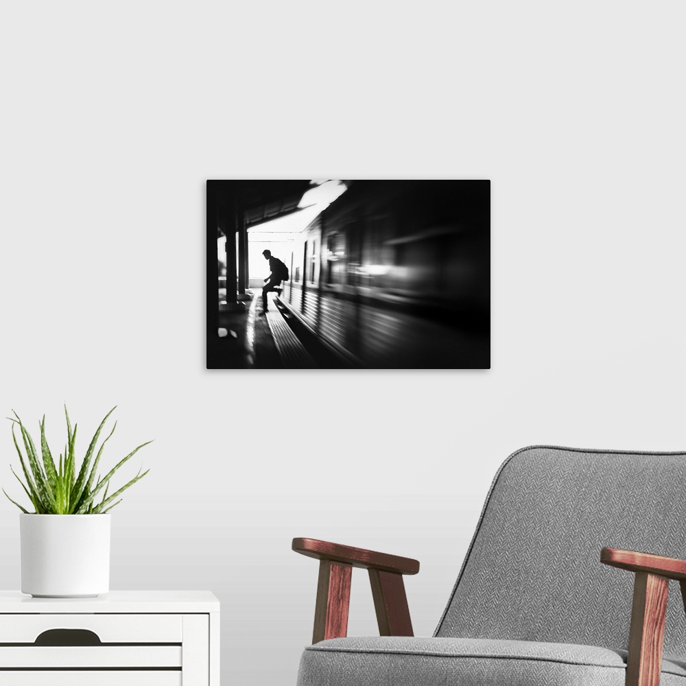 A modern room featuring Blurred motion image of a man jumping out of a train at the station in Jakarta.