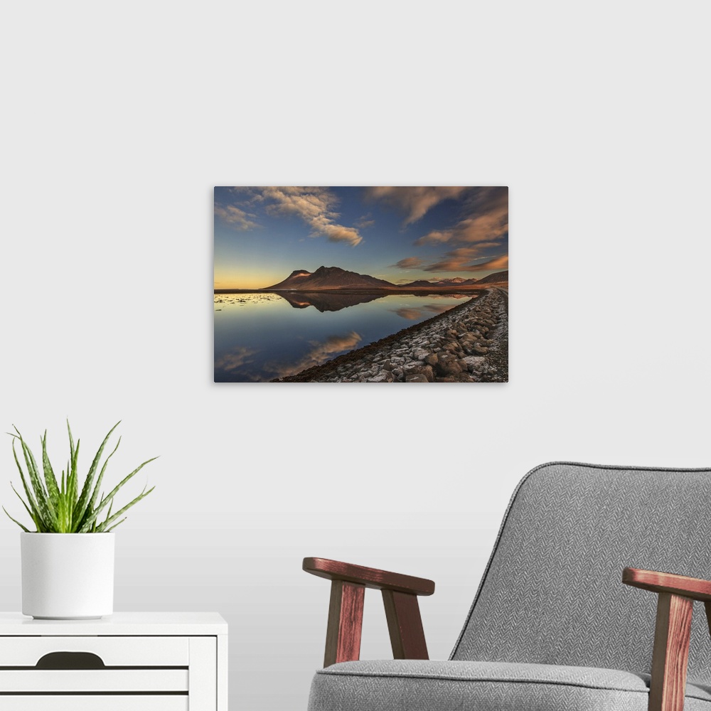A modern room featuring Early evening view of Bjarnarhafnarfjall mountain reflected in calm water, Snaefellsnes peninsula...