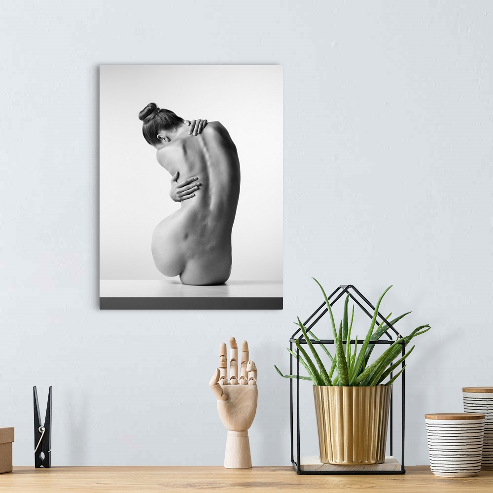 A bohemian room featuring Black and white fine art photograph of a nude woman from behind creating movement with her body.