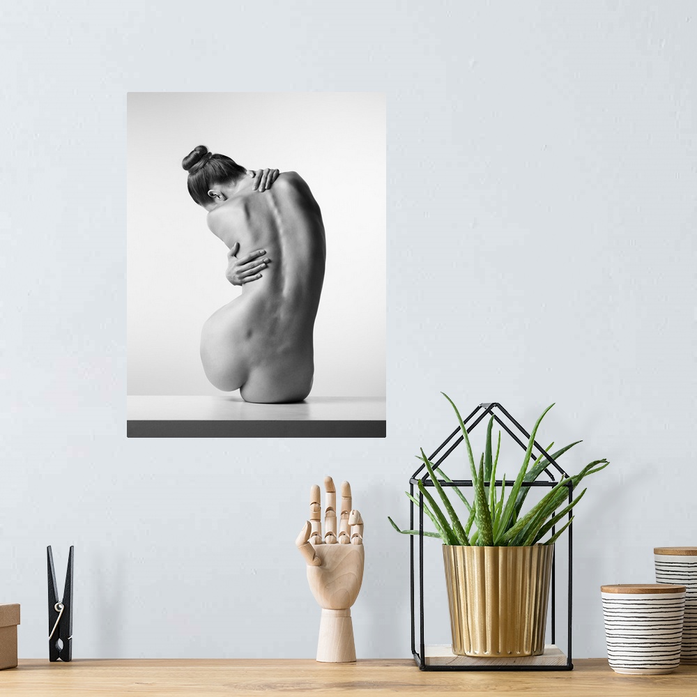 A bohemian room featuring Black and white fine art photograph of a nude woman from behind creating movement with her body.