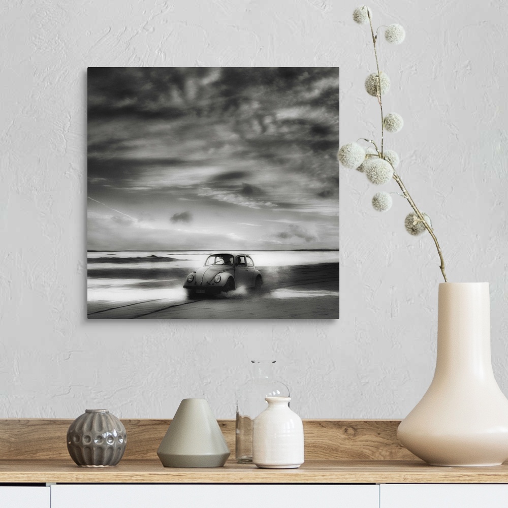A farmhouse room featuring A Volkswagen Beetle driving down a sandy beach with stunning clouds overhead.