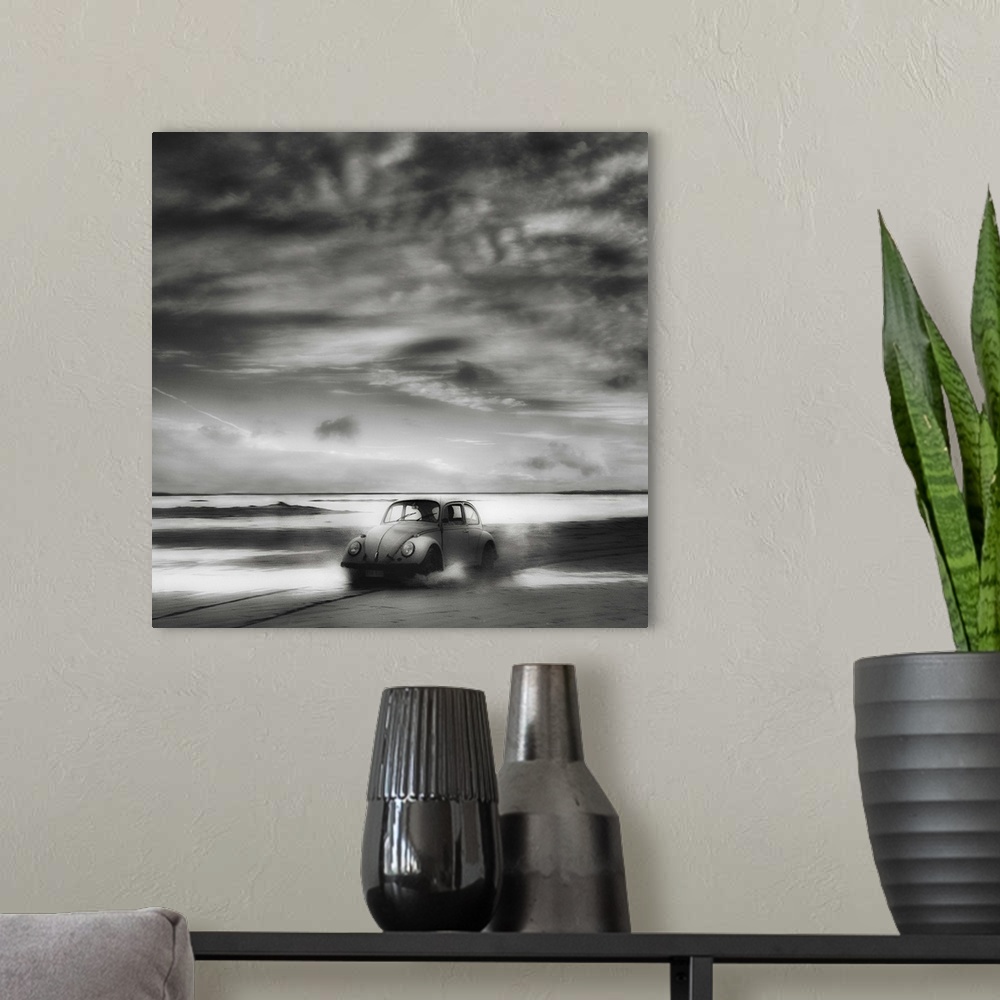 A modern room featuring A Volkswagen Beetle driving down a sandy beach with stunning clouds overhead.