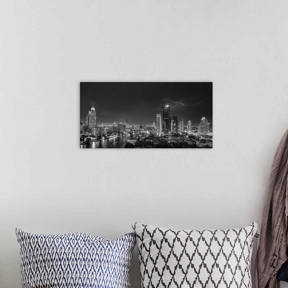 A bohemian room featuring An aerial photograph of the Bangkok skyline with lightning overhead.