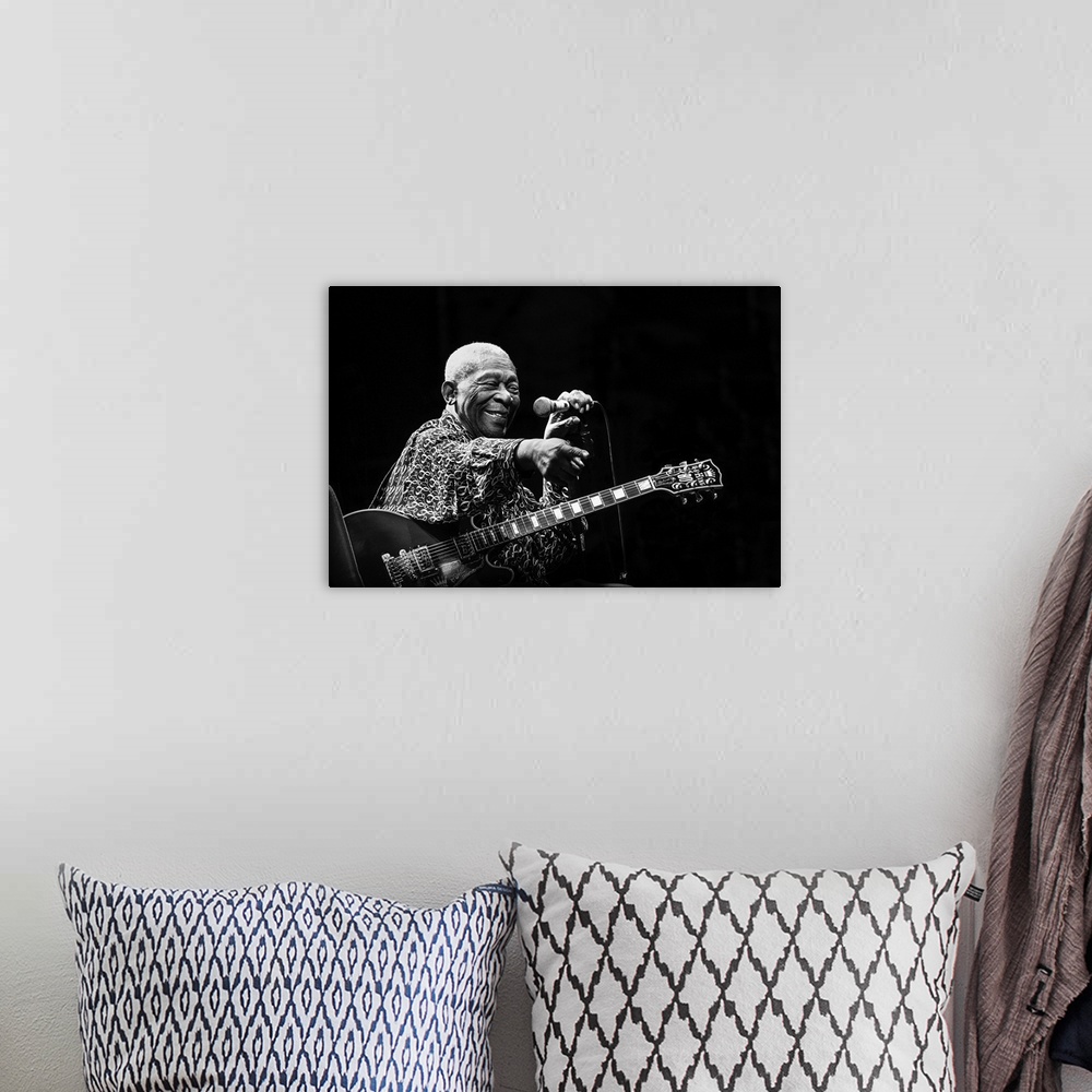 A bohemian room featuring Portrait of a blues musician on stage pointing to a fan in the crowd.
